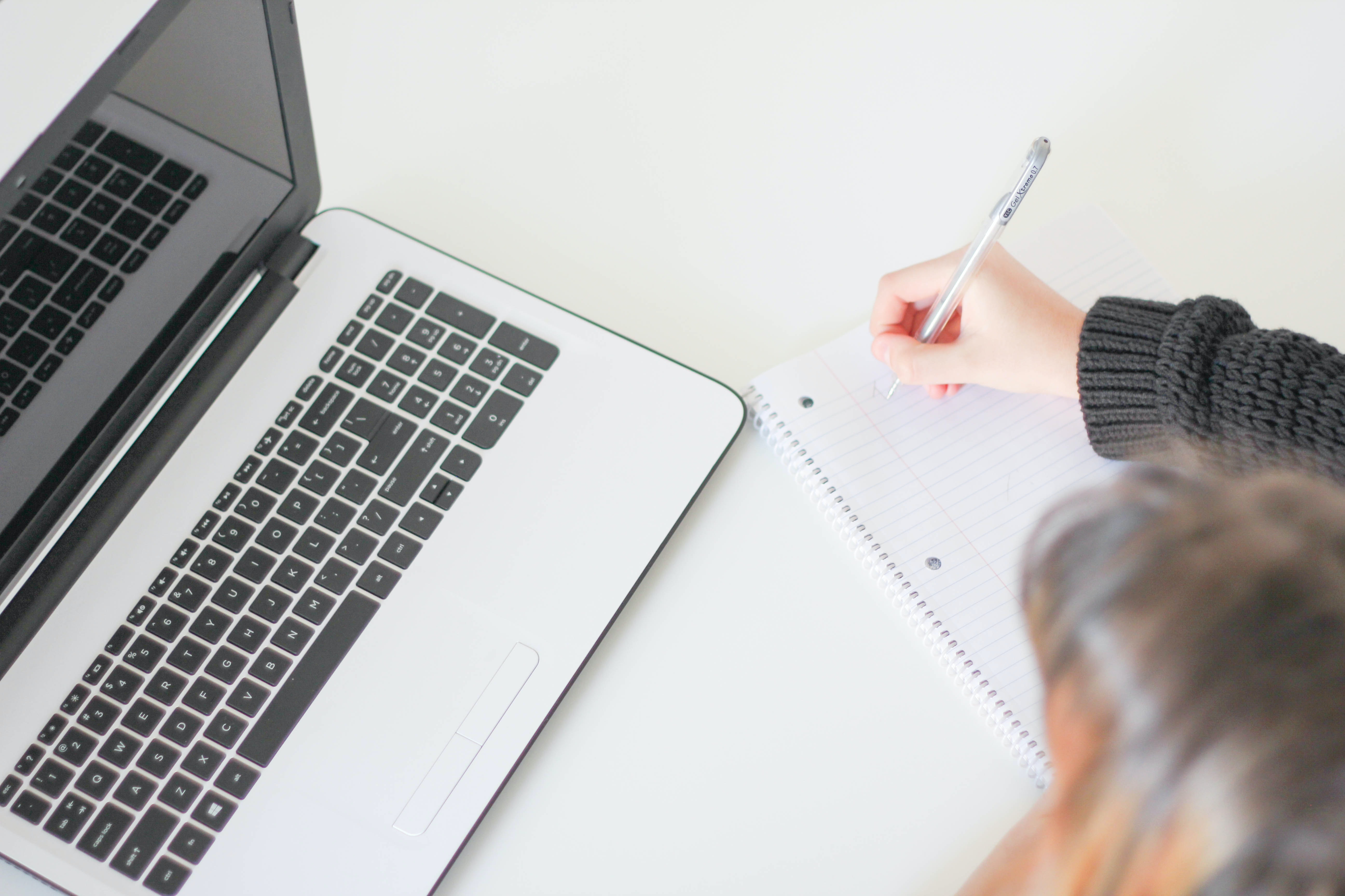 Person taking notes from computer