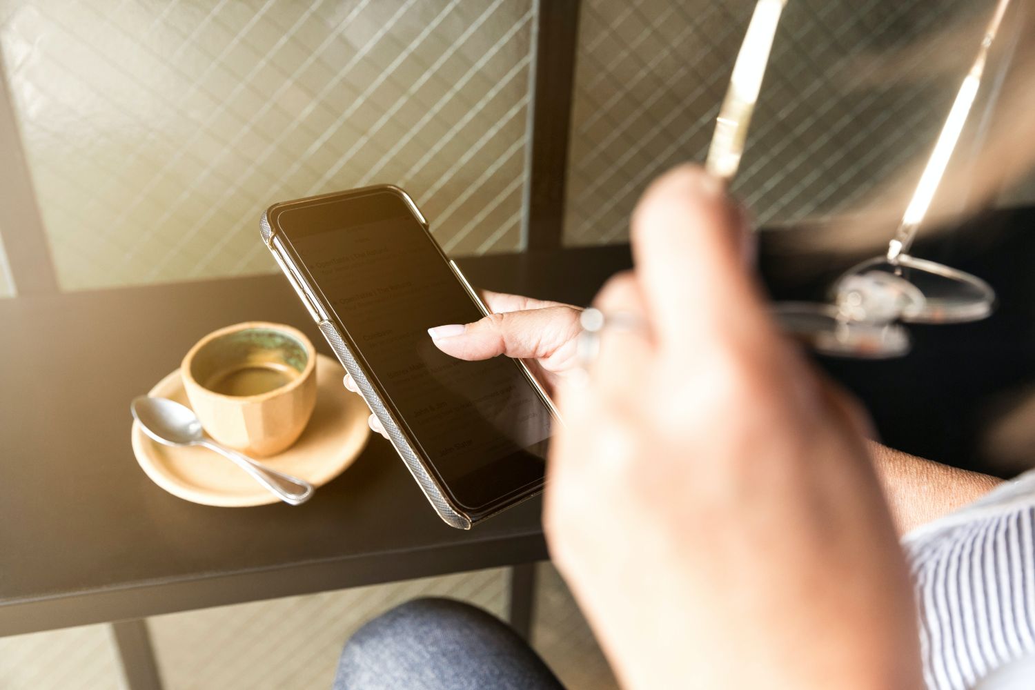 Person using phone drinking coffee