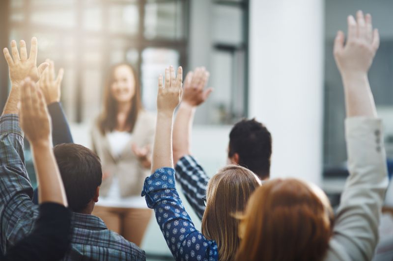 People raising there hand to answer a question