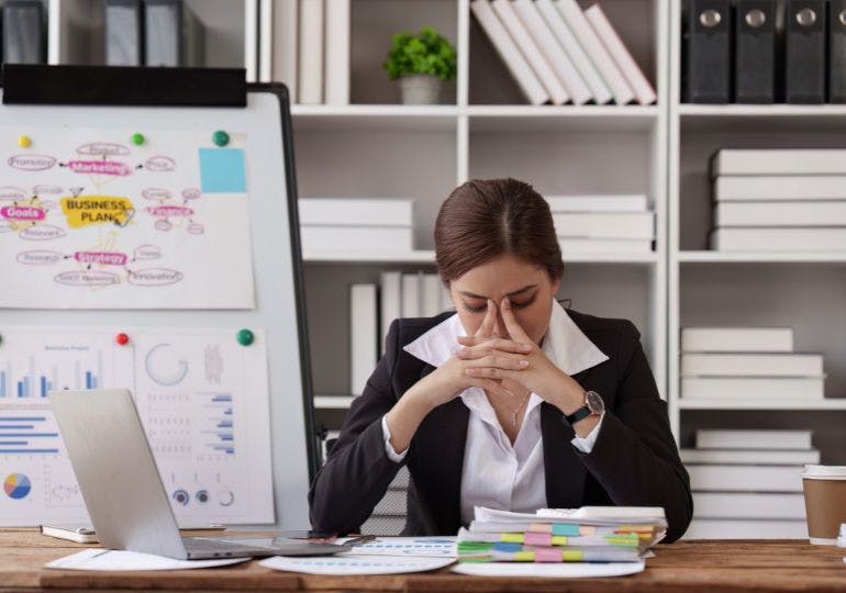 A person visible stressed whilst sitting in the office